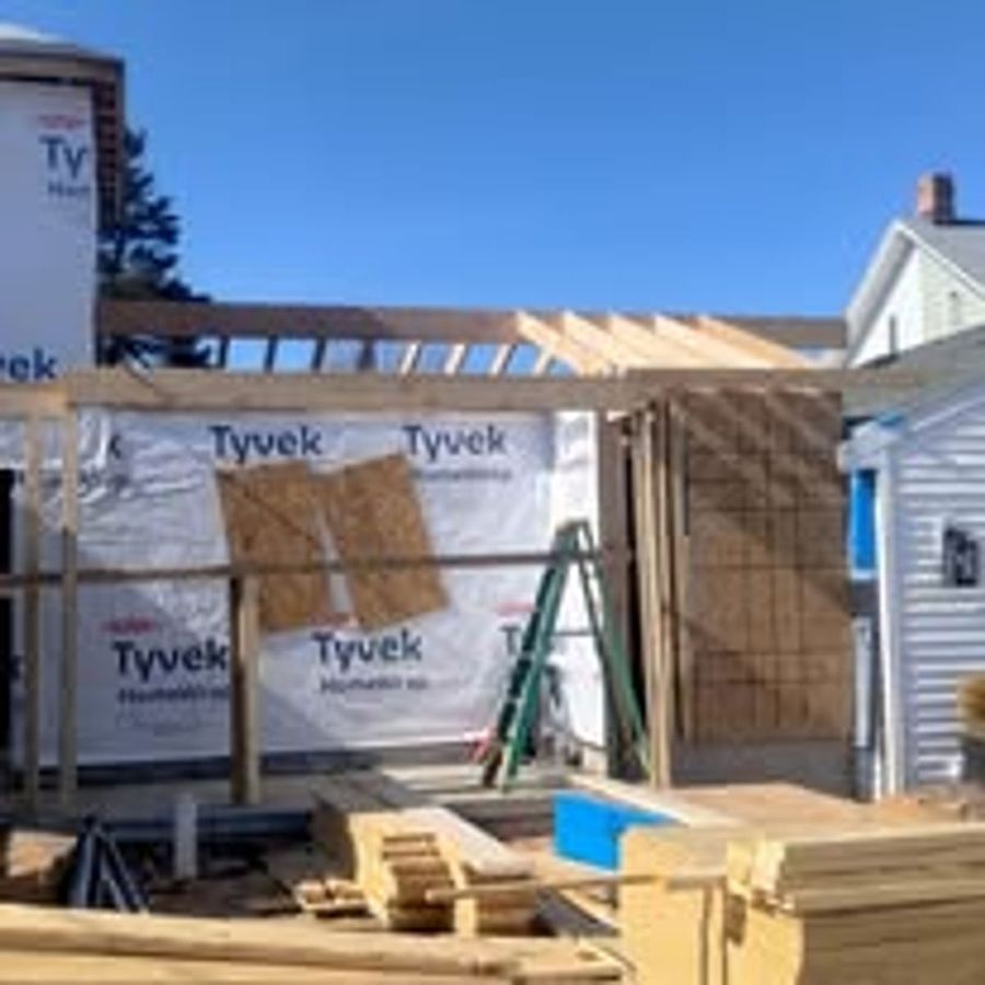 Addition under construction with roof framing and Tyvek house wrap in place