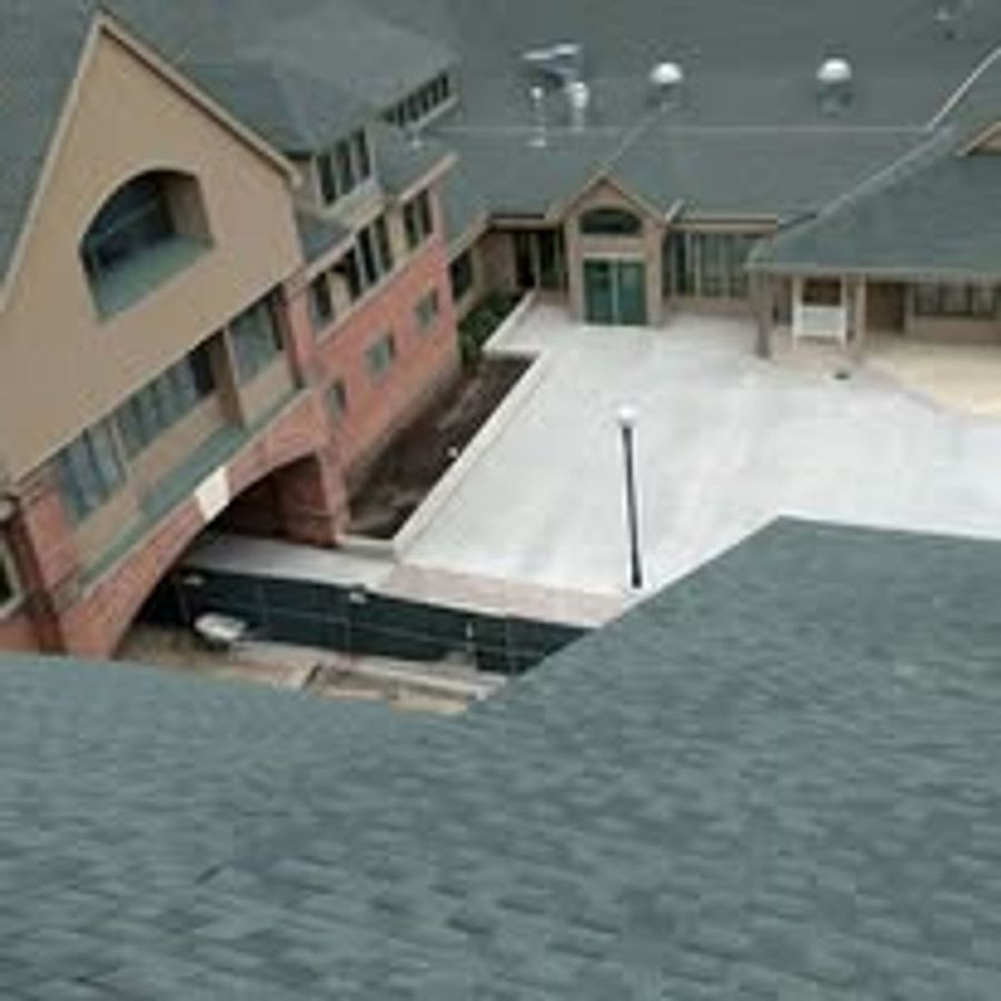 Close view of a new gray shingle roof on a contemporary multi-level home