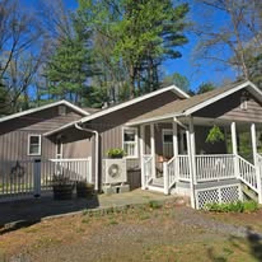 Single-story home with a covered front porch, railings, and new brown siding